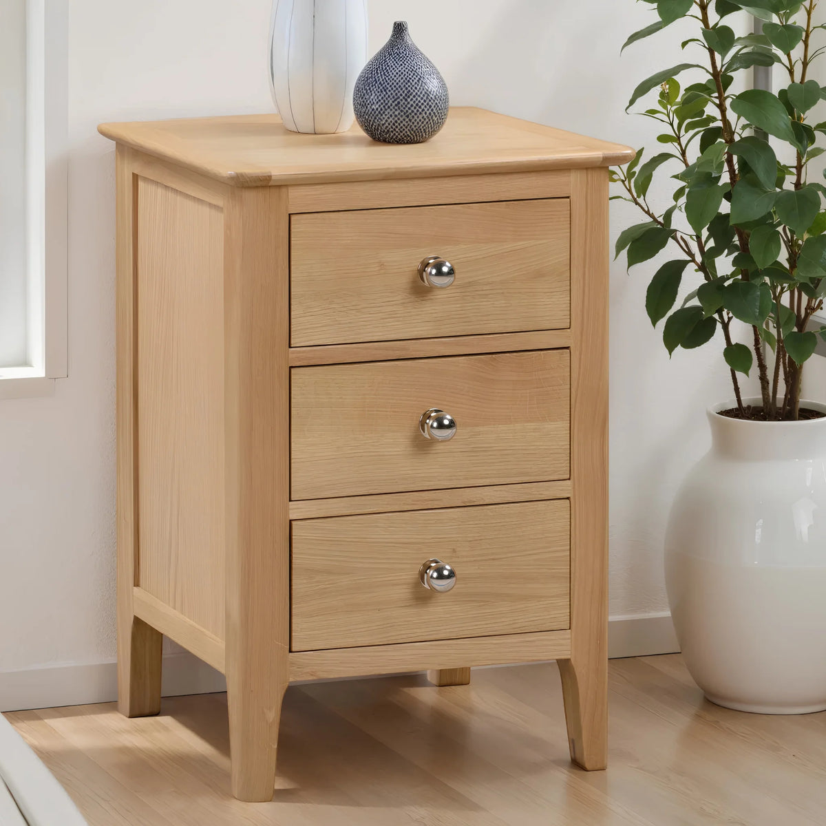 Cotswold Oak 3-Drawer Bedside Chest – angled front and side view in room setting